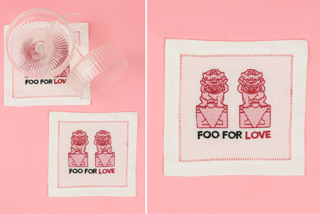 Clear Glass Ribbed Cocktail Glass or Coupe Glass with white and pink embroidered cocktail napkins with foo dog and embroidered typography "Foo For Love" from Design Ten 1 and From 6th Collective in Amarillo Texas. Galentine's product gift guide