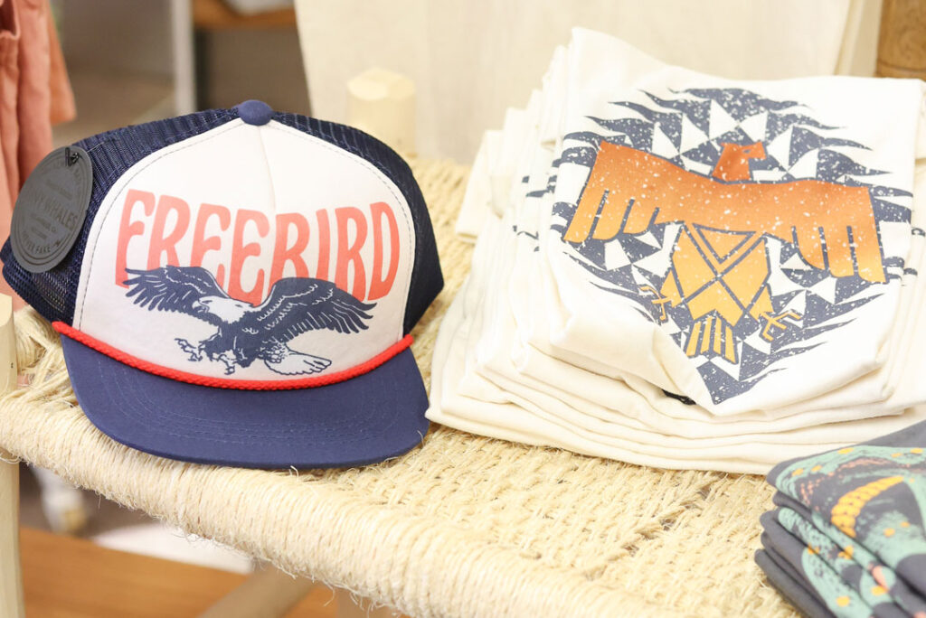 Blue, White, and Red trucker hat with eagle and "freebird" in text with native eagle pattern on a white graphic tee. Kids clothing and children's toy store in dumas texas
