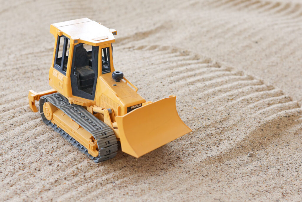 Yellow tonka truck, bulldozer in sand box or sand pit at Just Dig It, a children's indoor play room.
