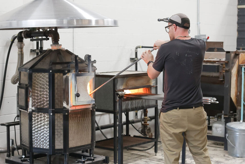 Clayton Spaulding heating glass to sculpt in the design studio.